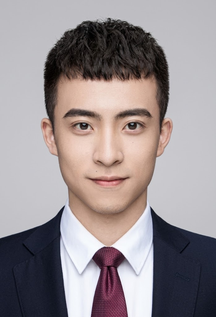 Young male project communication specialist with glasses, in a charcoal shirt, seated in a logistics coordination office
