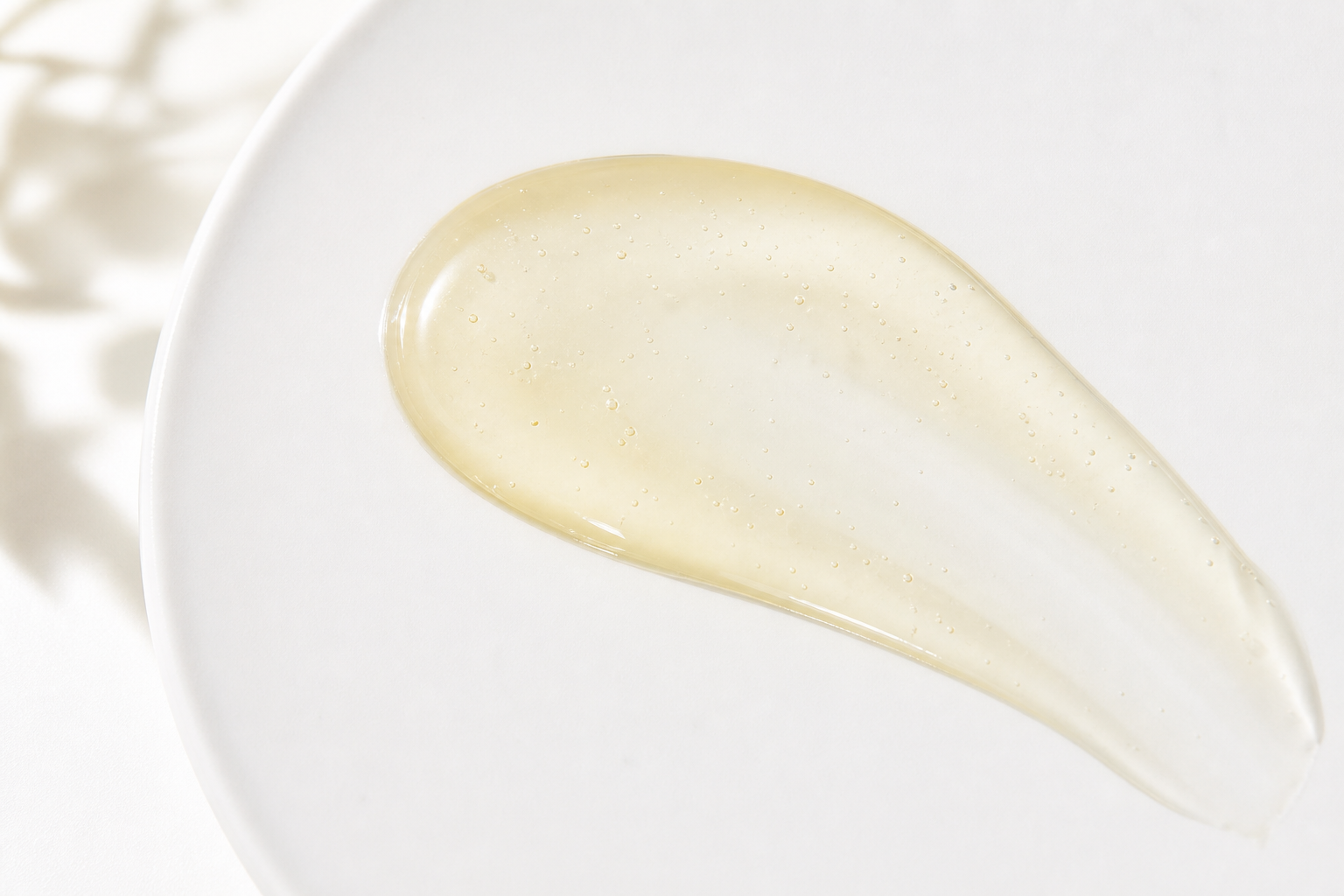 Vitamin C serum swatch with a glossy sheen on a white palette