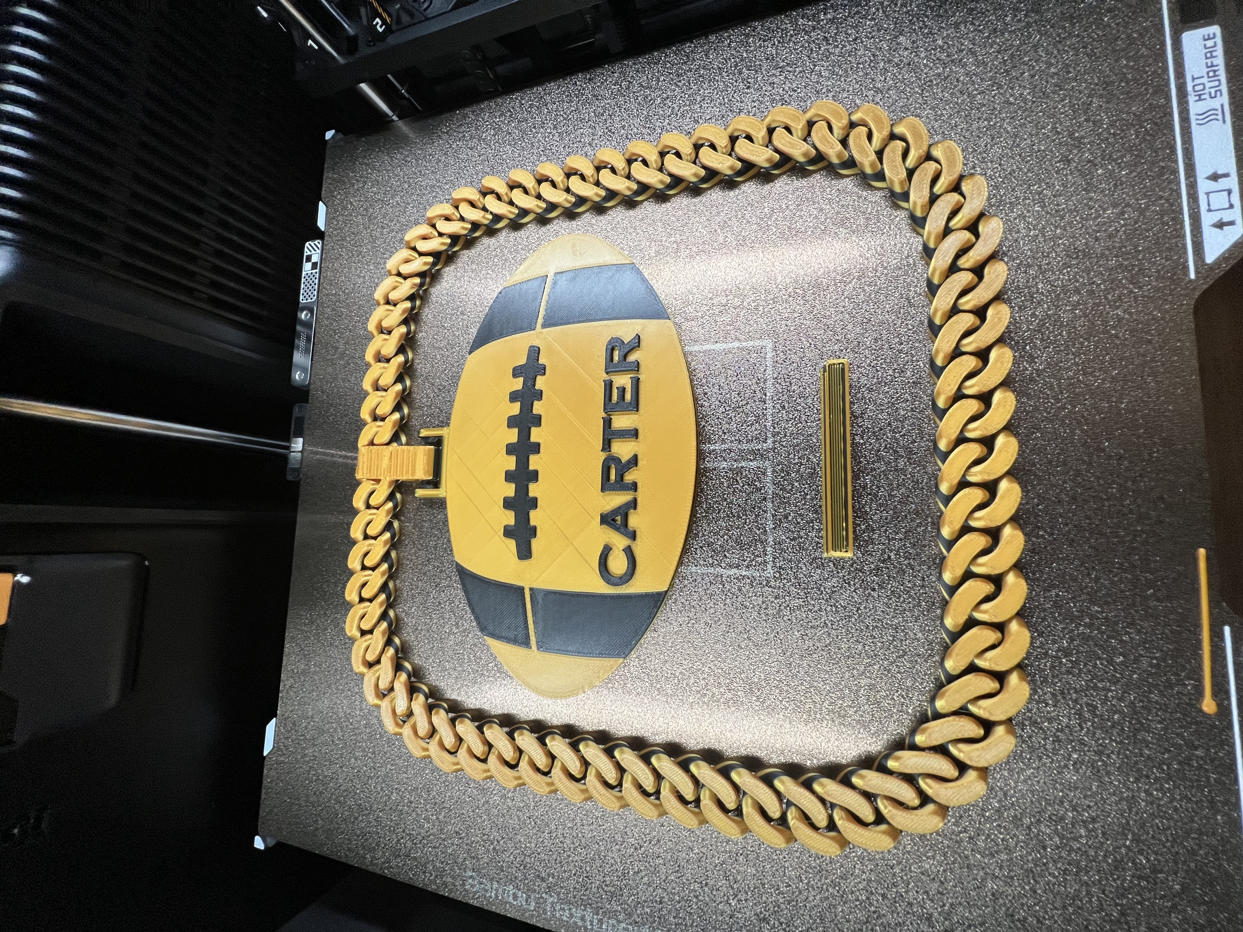 Custom 3D product piece with chain detail and Carter label in black and gold filament.