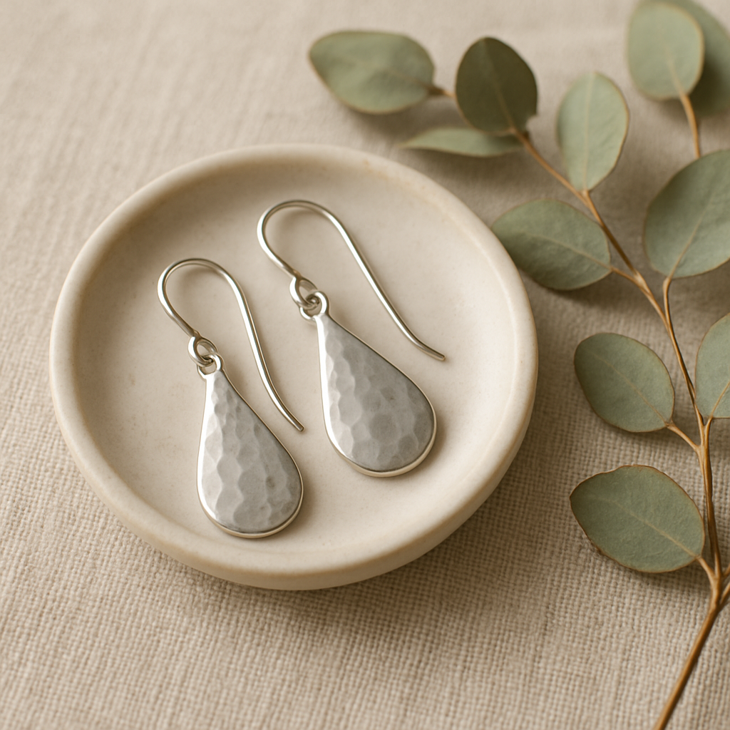 Hammered drop earrings on a ceramic dish