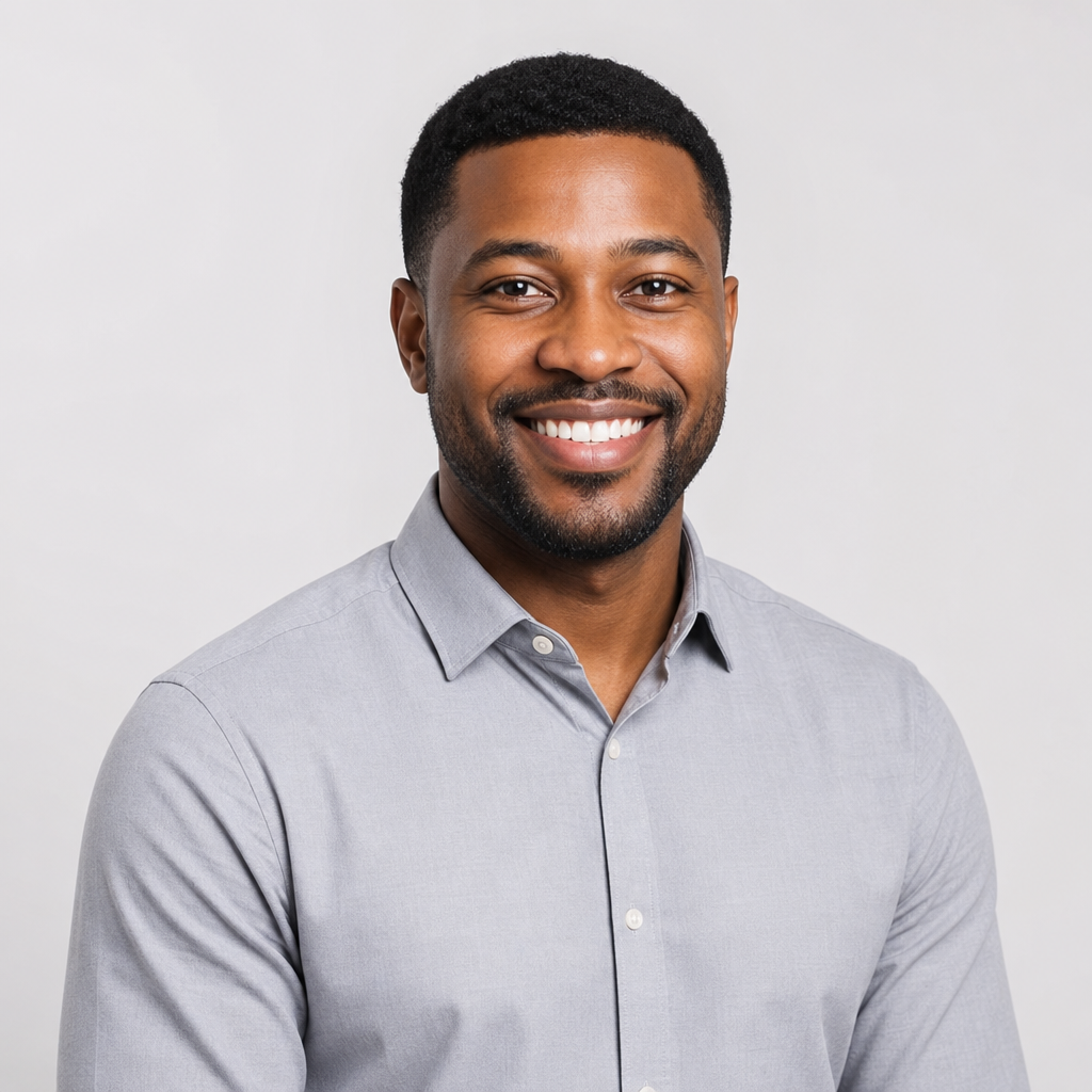 Portrait of Tunde Adebayo, a smiling man with short hair wearing a light gray shirt