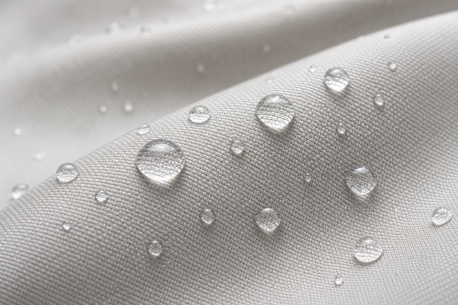 Macro shot of water droplets beading on a technical curtain fabric surface