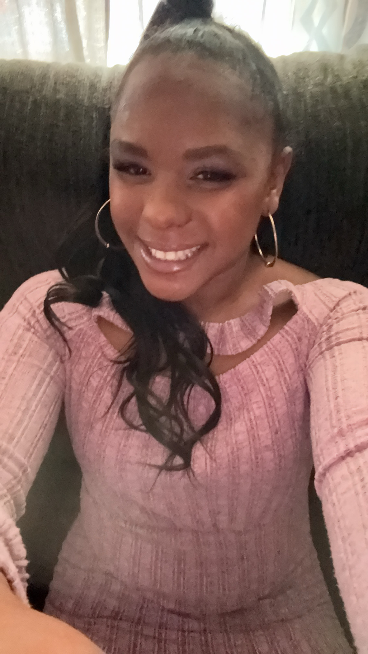 Smiling young woman holding a freshly baked chocolate chip cookie