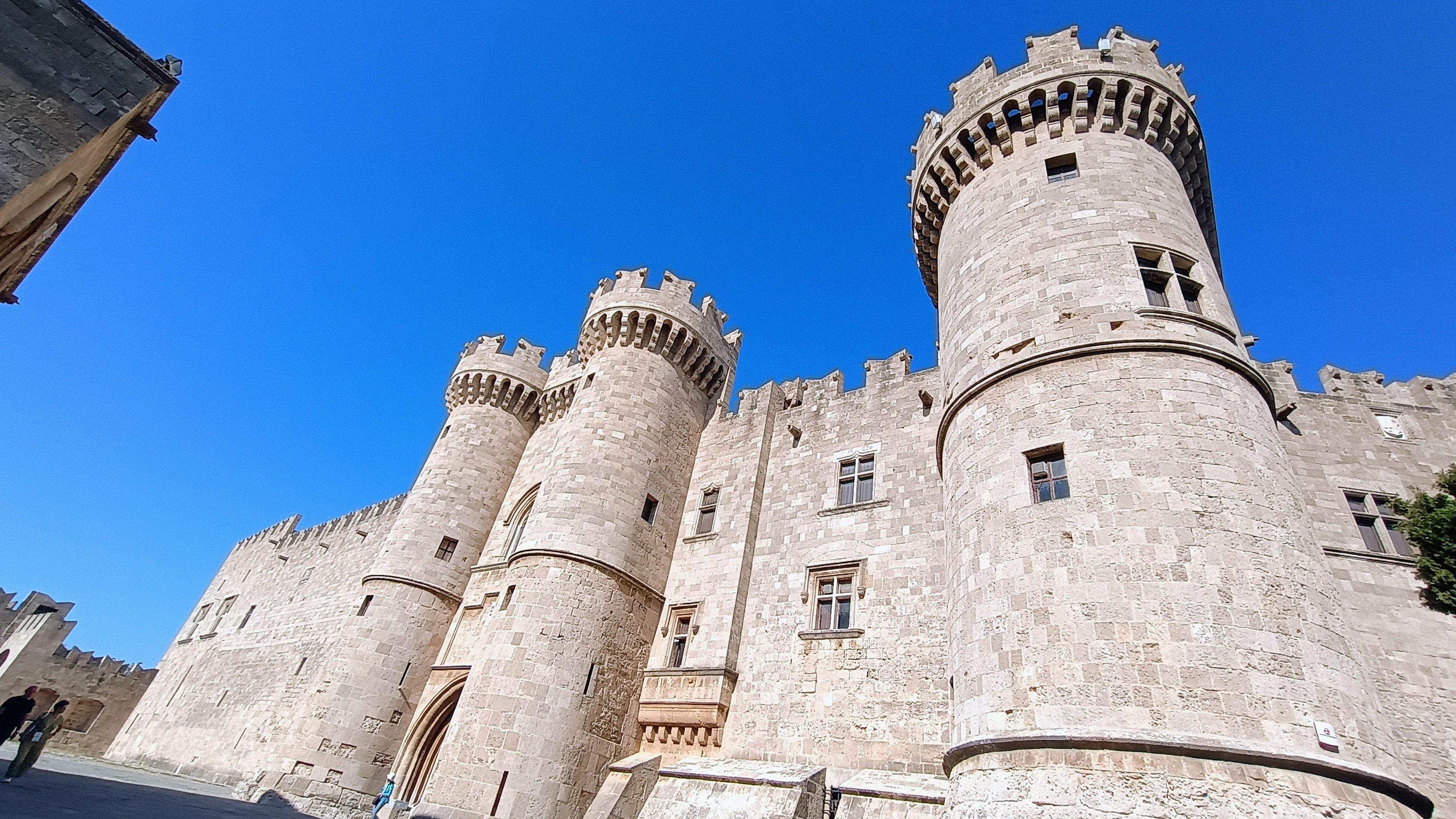 Historic stone fortress walls and towers under a clear sky, showcasing a heritage filming location in Greece