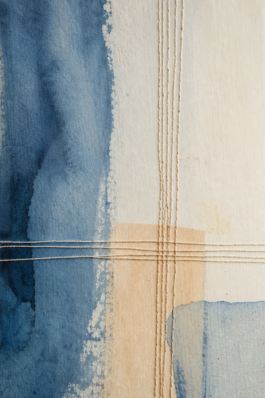 Close crop of stitched linework crossing muted blue paint
