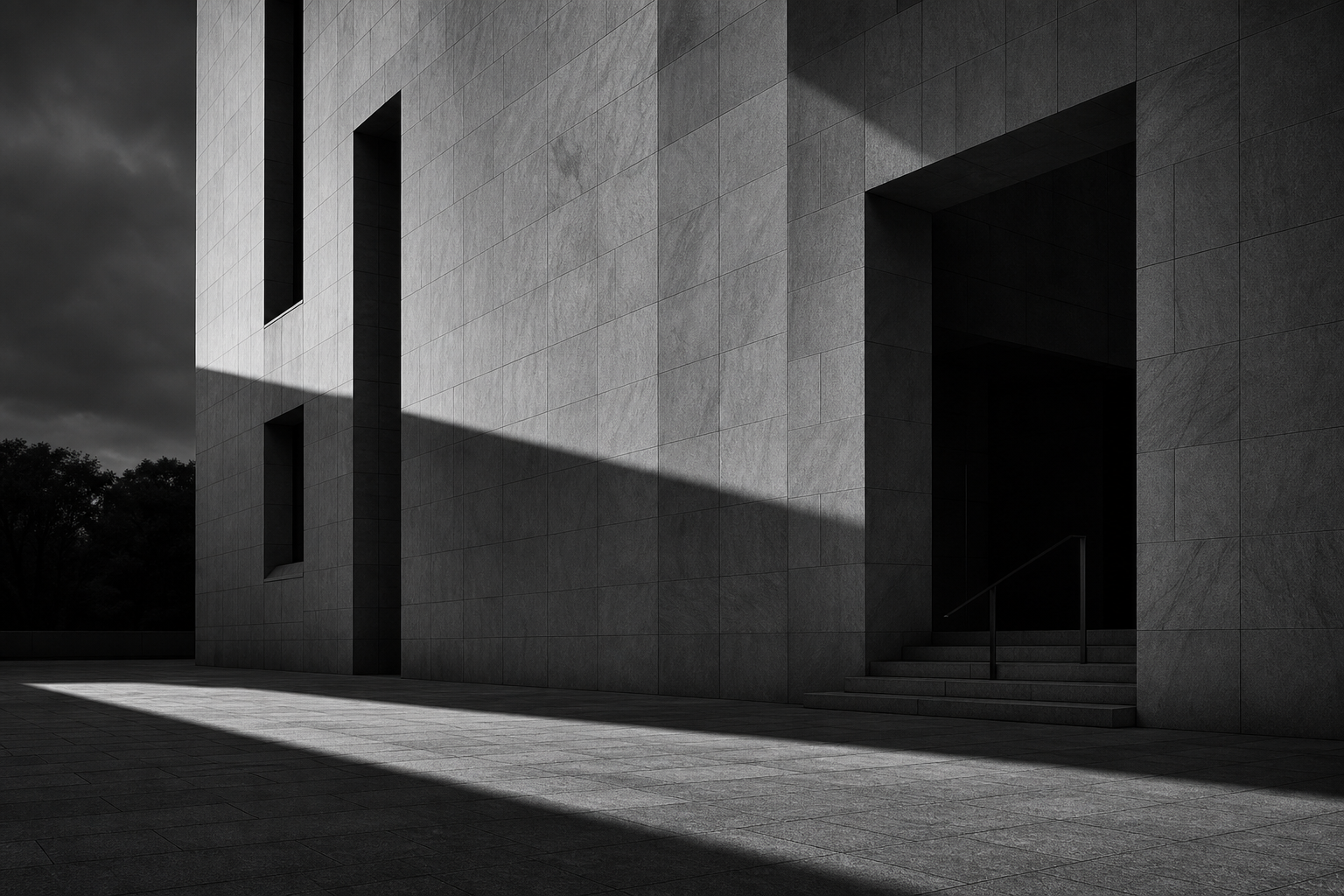 Large monochrome architectural facade with long shadows across an empty civic plaza