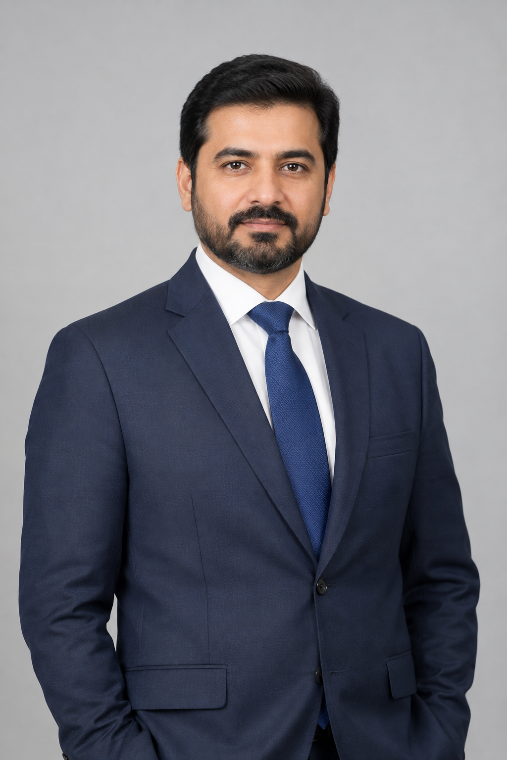 Professional portrait of Advocate Mayo Best in a dark navy suit and tie against a neutral studio background