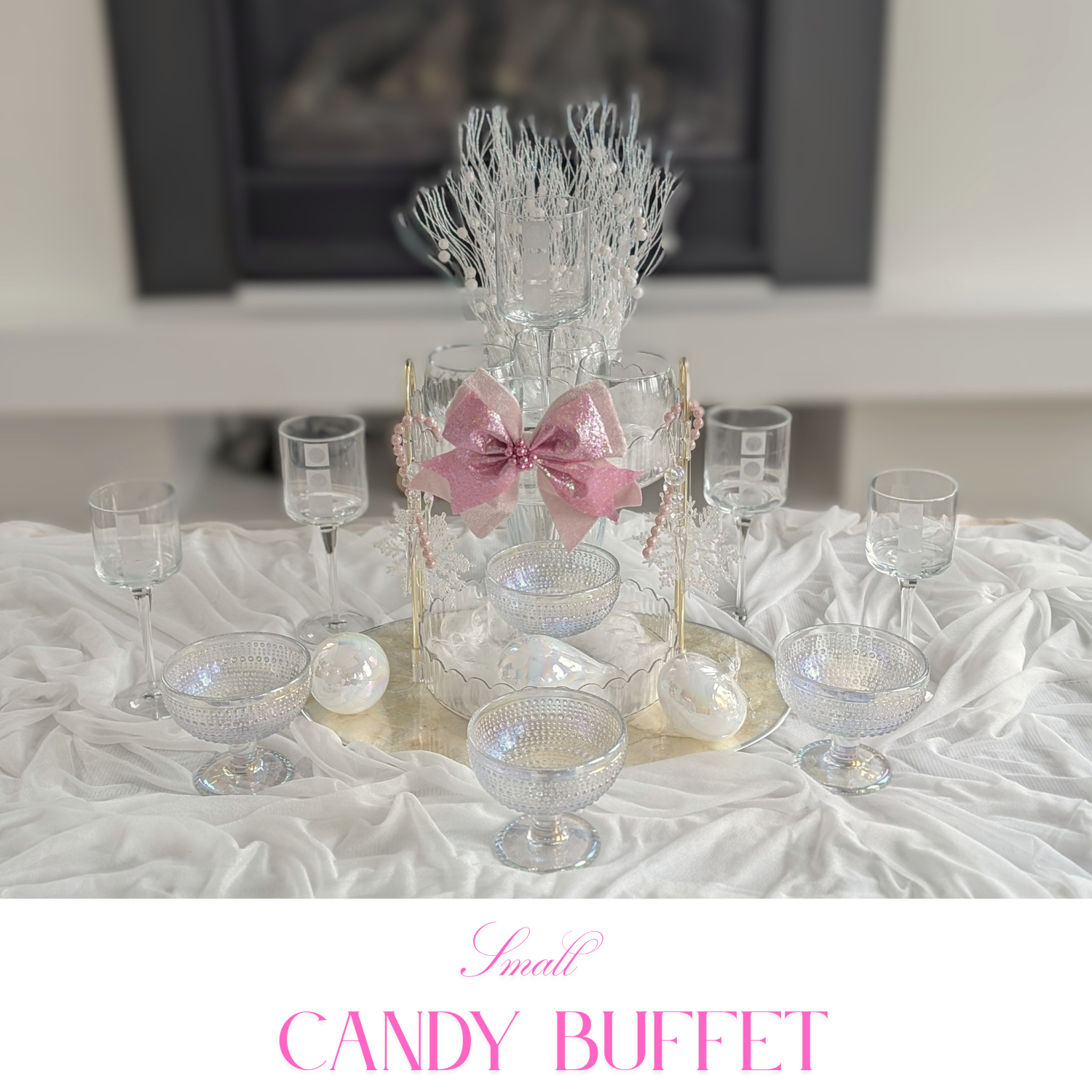Pastel baby shower candy table with pale pink jars, white cake stands, and ribbon details