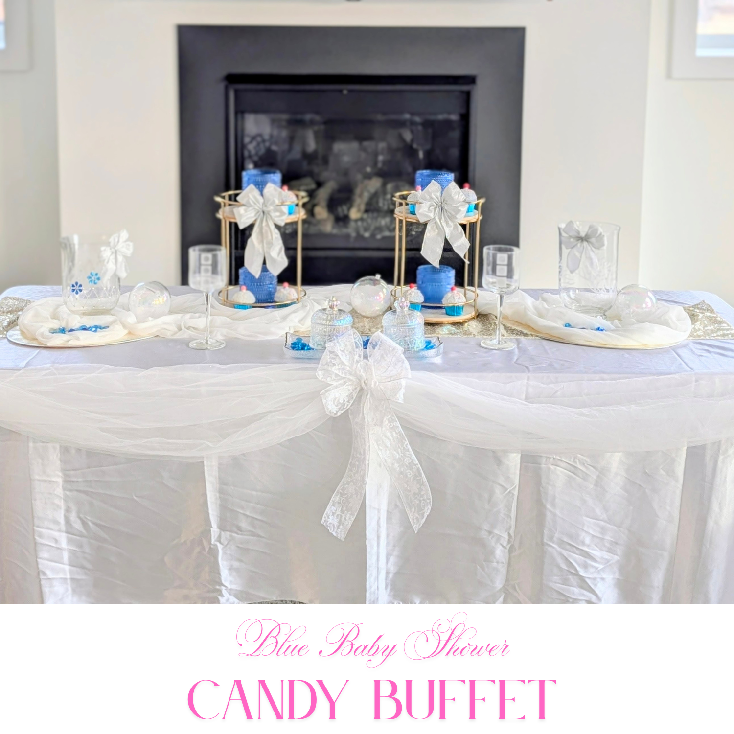 Blue baby shower candy buffet setup with white draping, silver accents, and twin gold risers