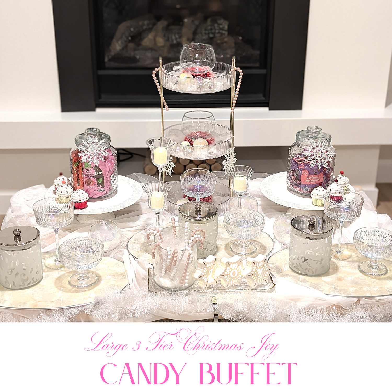 Joy-themed Christmas candy buffet with silver and blush accents, tiered trays, and candlelit holiday styling