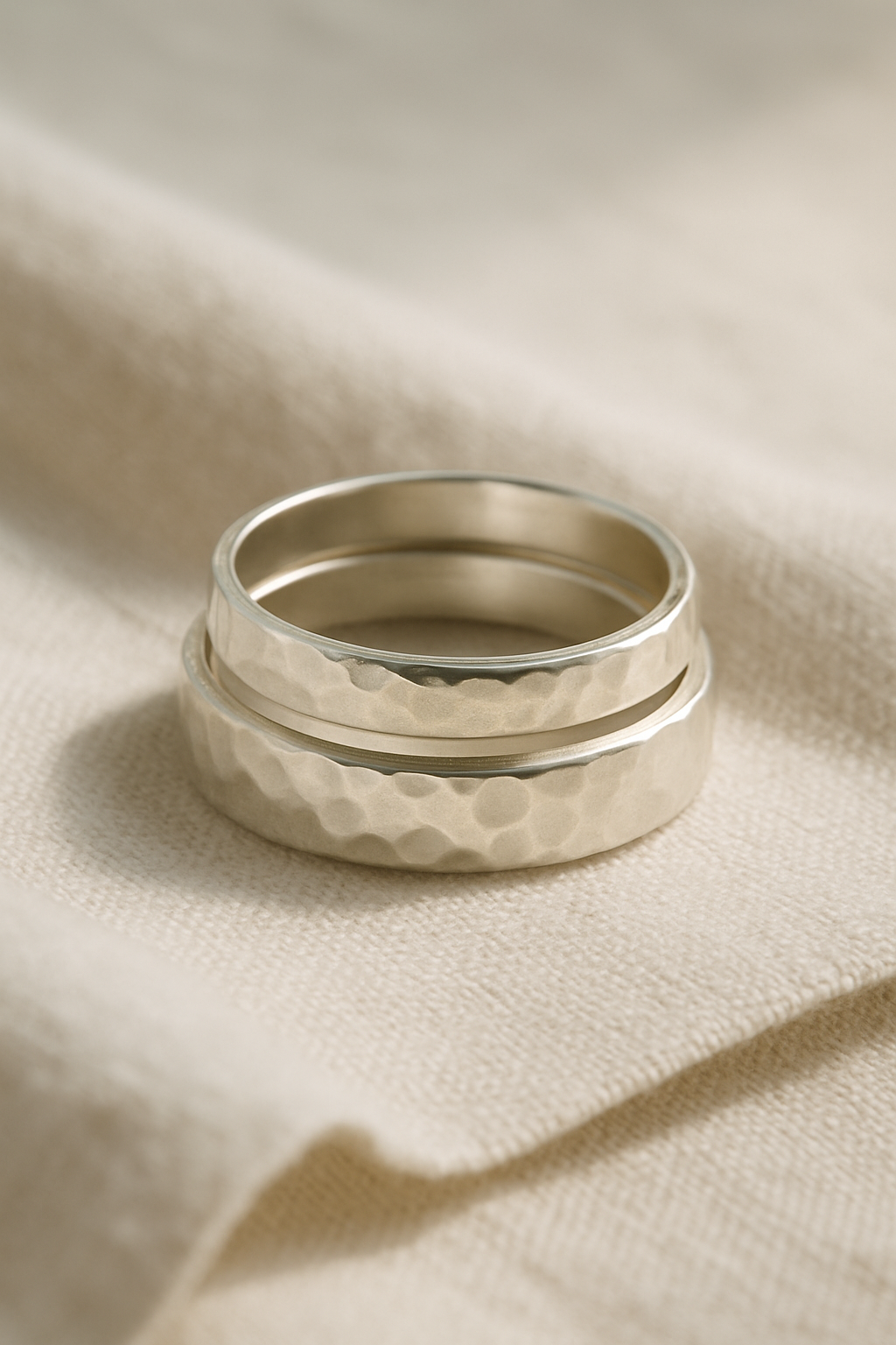 Hand-hammered sterling silver stacking rings on linen
