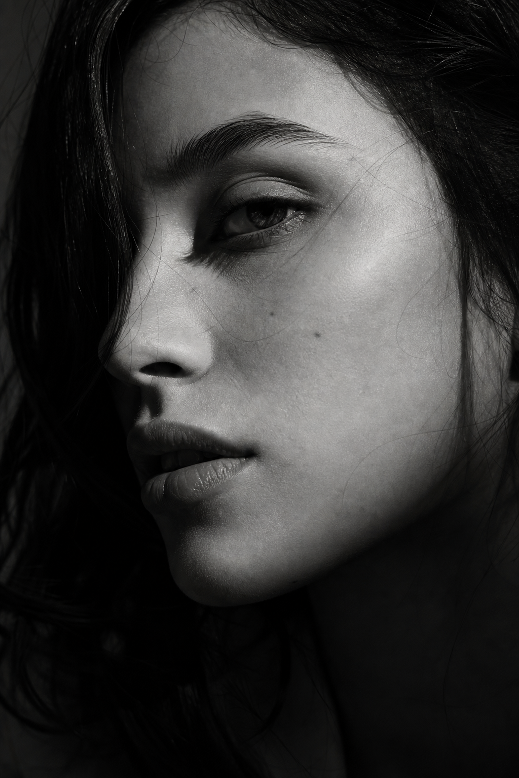 Dramatic black and white close-up portrait with strong side lighting