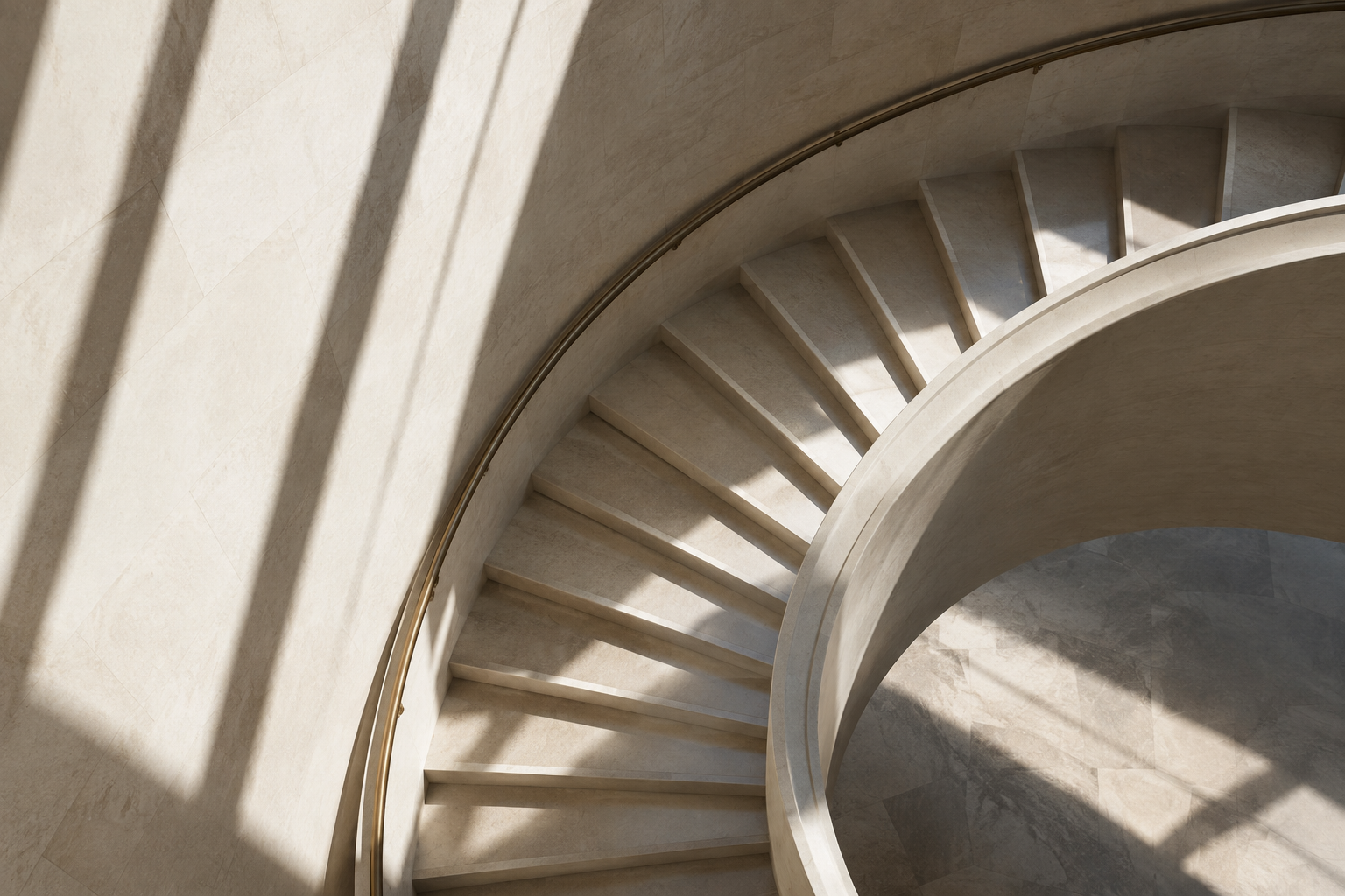 Spiral museum stairwell in pale limestone with strong diagonal afternoon shadows