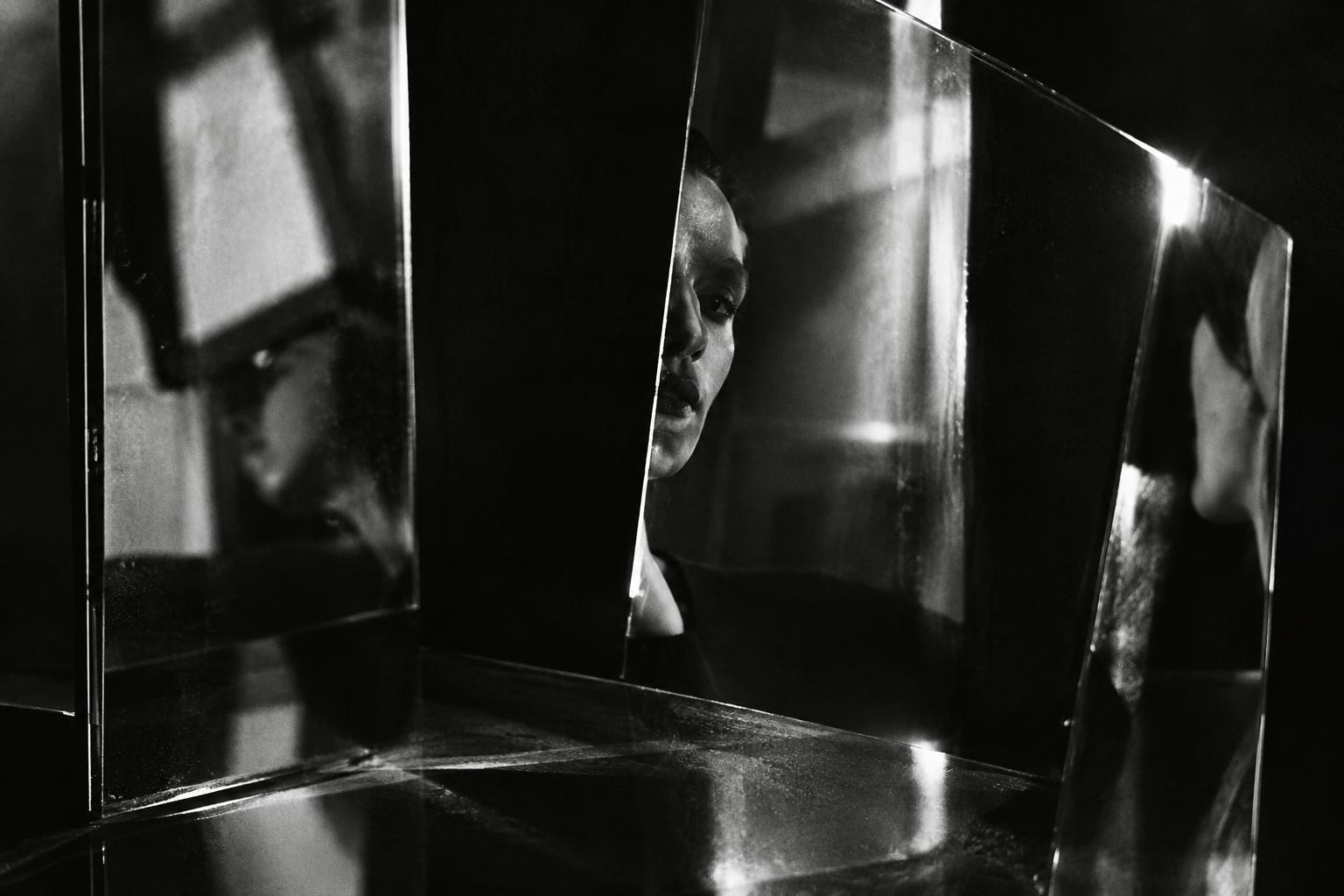 experimental darkroom photograph with fragmented reflections and high contrast shadows