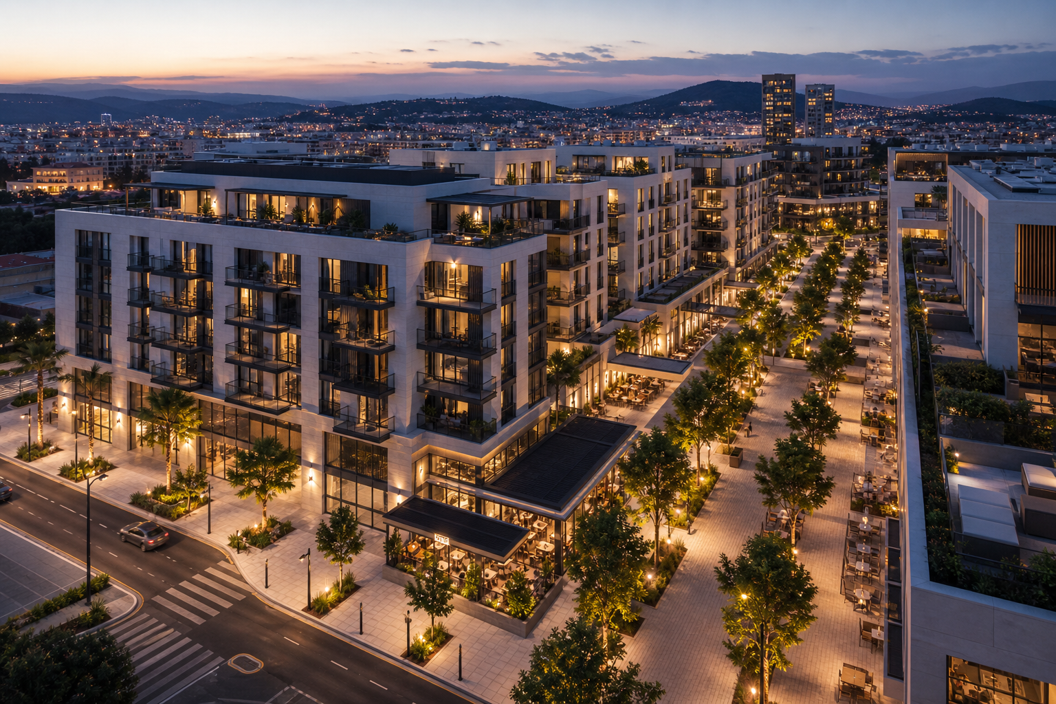 Aerial view of a modern mixed-use real estate development in Spain at dusk, featuring elegant mid-rise residential buildings, a commercial plaza, and warm golden lighting