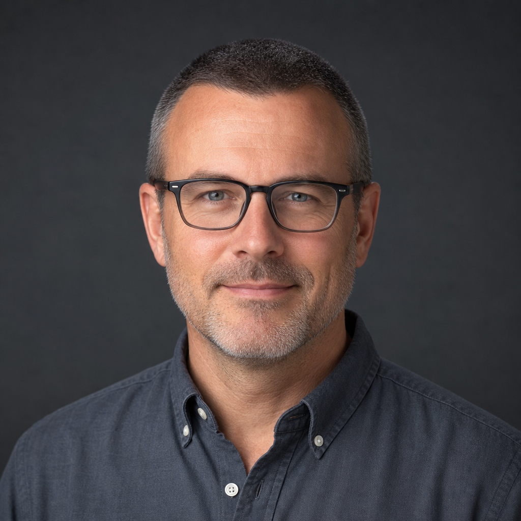 Portrait of Daniel Greene, a middle-aged man with close-cropped hair and glasses