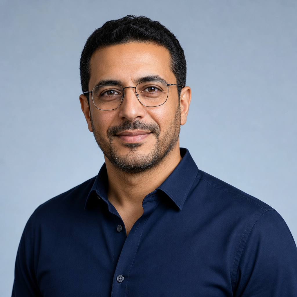Portrait of the Partnerships Manager wearing glasses, a navy shirt, and a calm professional smile