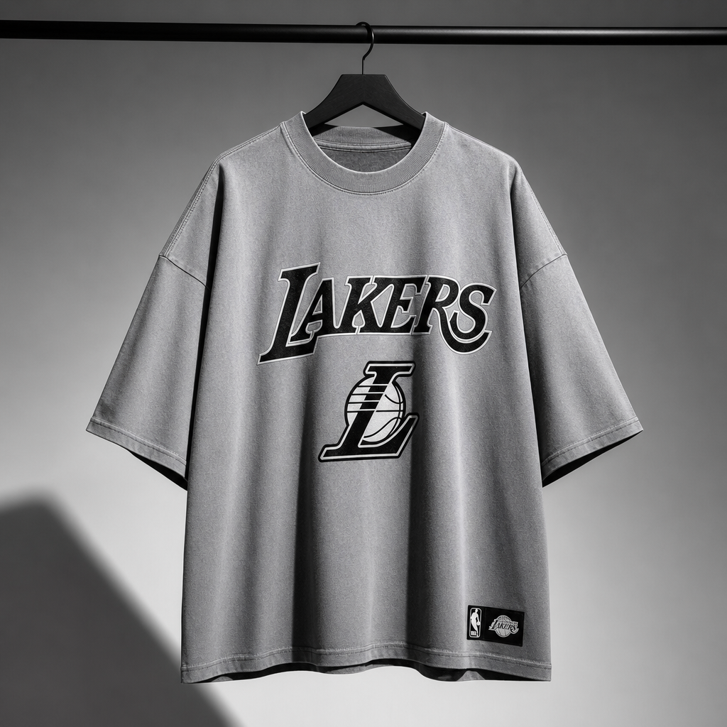 Camiseta gris de Lakers — Cuello redondo, colgada en percha, gráfico frontal centrado.