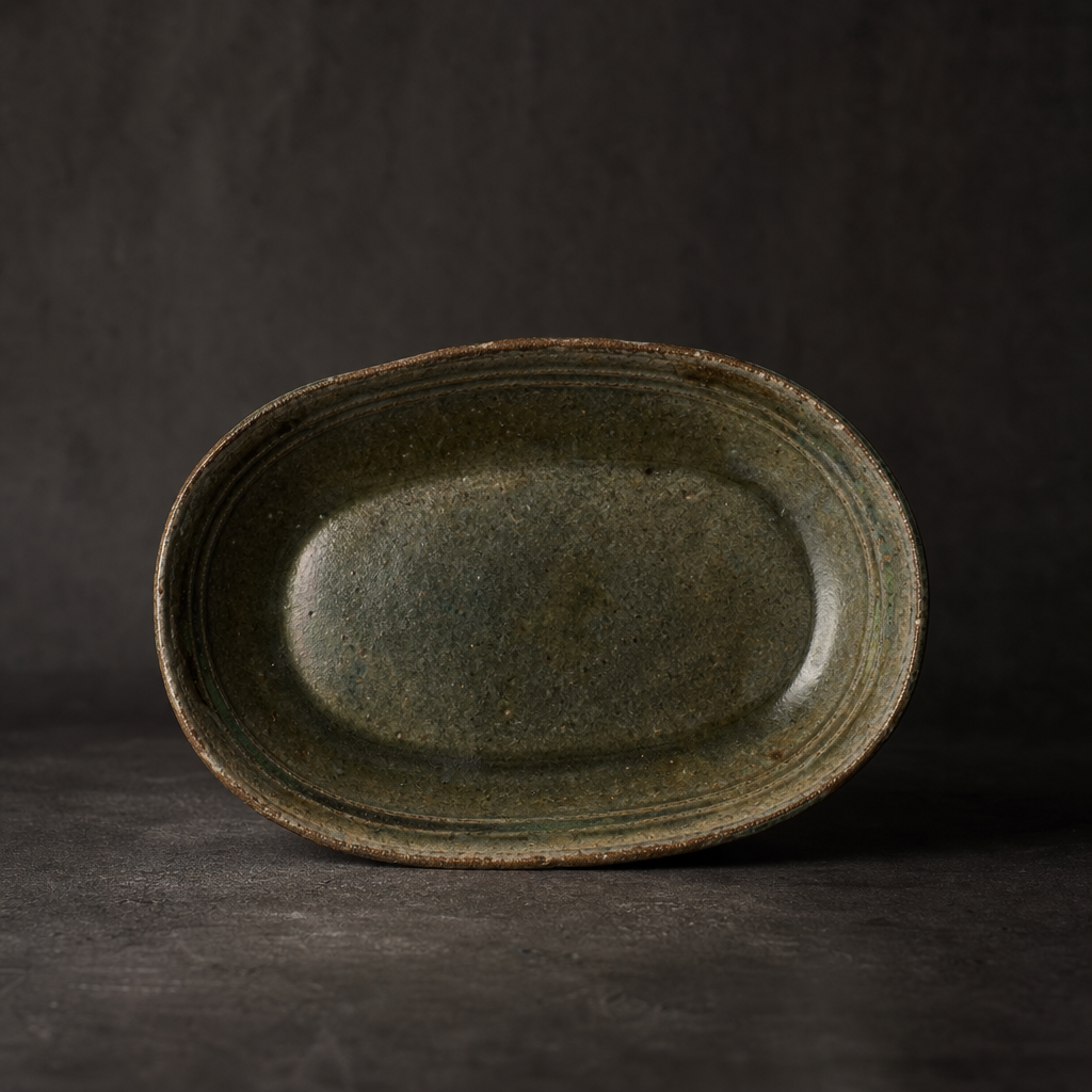 Antique Plate II, oval stoneware plate with moss-toned glaze and softly weathered edges