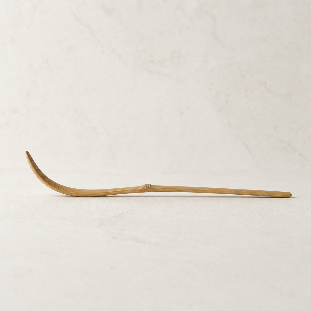 Side profile of the bamboo scoop showing its gentle arc