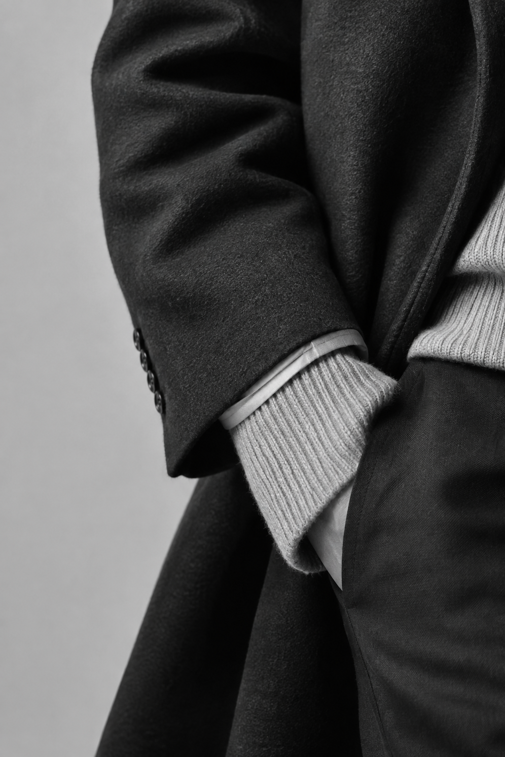 Cropped monochrome fashion detail showing knit texture and tailored sleeve styling