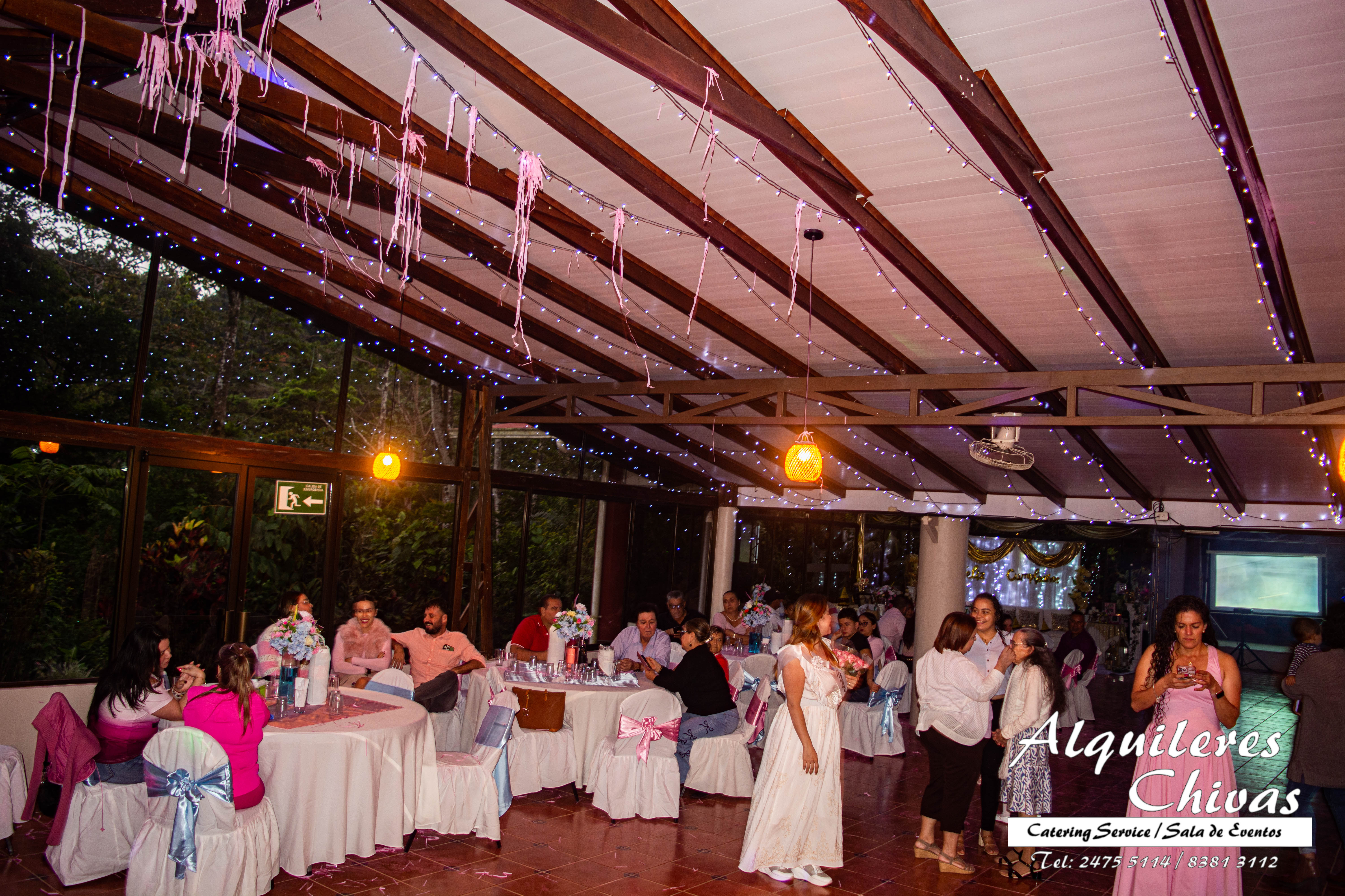Celebración de baby shower en la sala de eventos, decoración en tonos pastel y mesa de dulces temática.