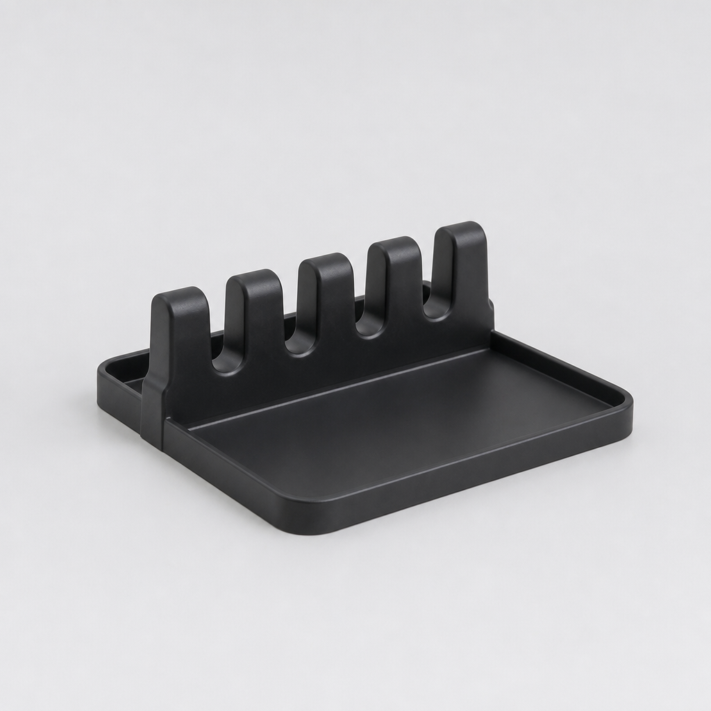 Slim countertop spatula rack with five slots in black plastic, photographed on light gray