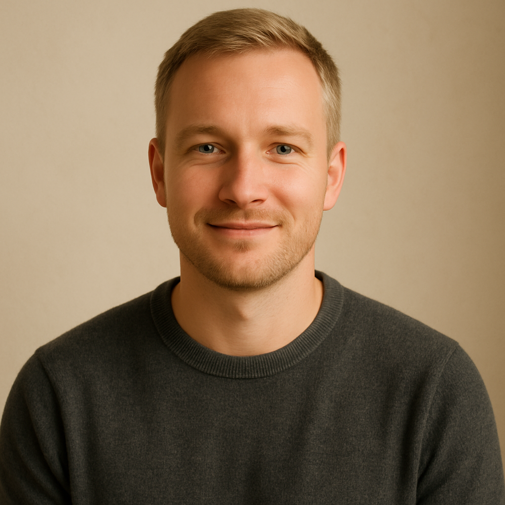 Man with light skin tone and short blond hair wearing a charcoal sweater