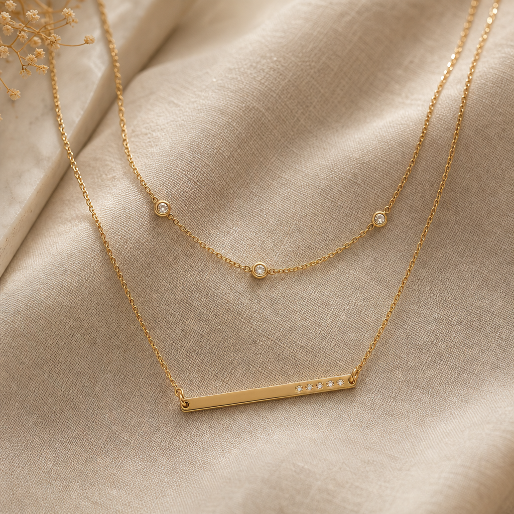 Layered gold chain necklace with a fine bar pendant and tiny diamond accents