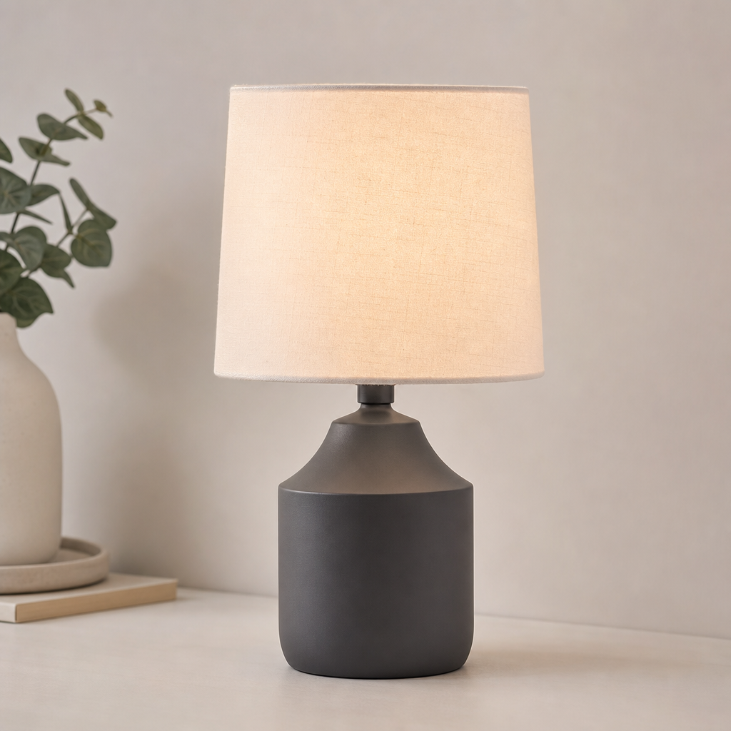 Modern table lamp with matte graphite base and warm white fabric shade