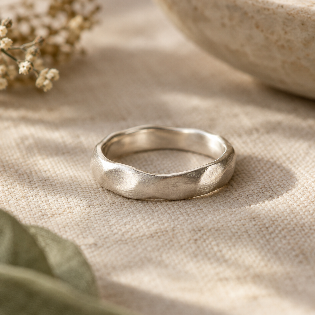 Close-up of a softly brushed sterling silver ring with a delicate hand-finished surface
