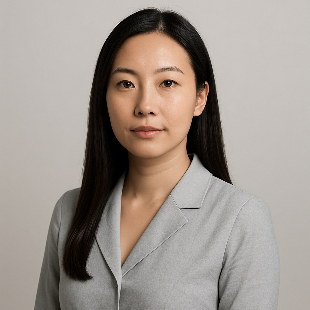 Professional headshot of an Asian woman with long straight hair wearing a light gray blouse