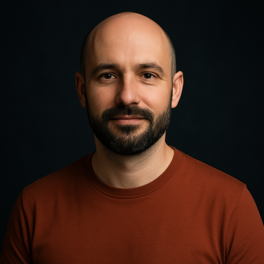 Taras Romaniuk, with a shaved head, a neatly trimmed dark beard and a rust-colored T-shirt