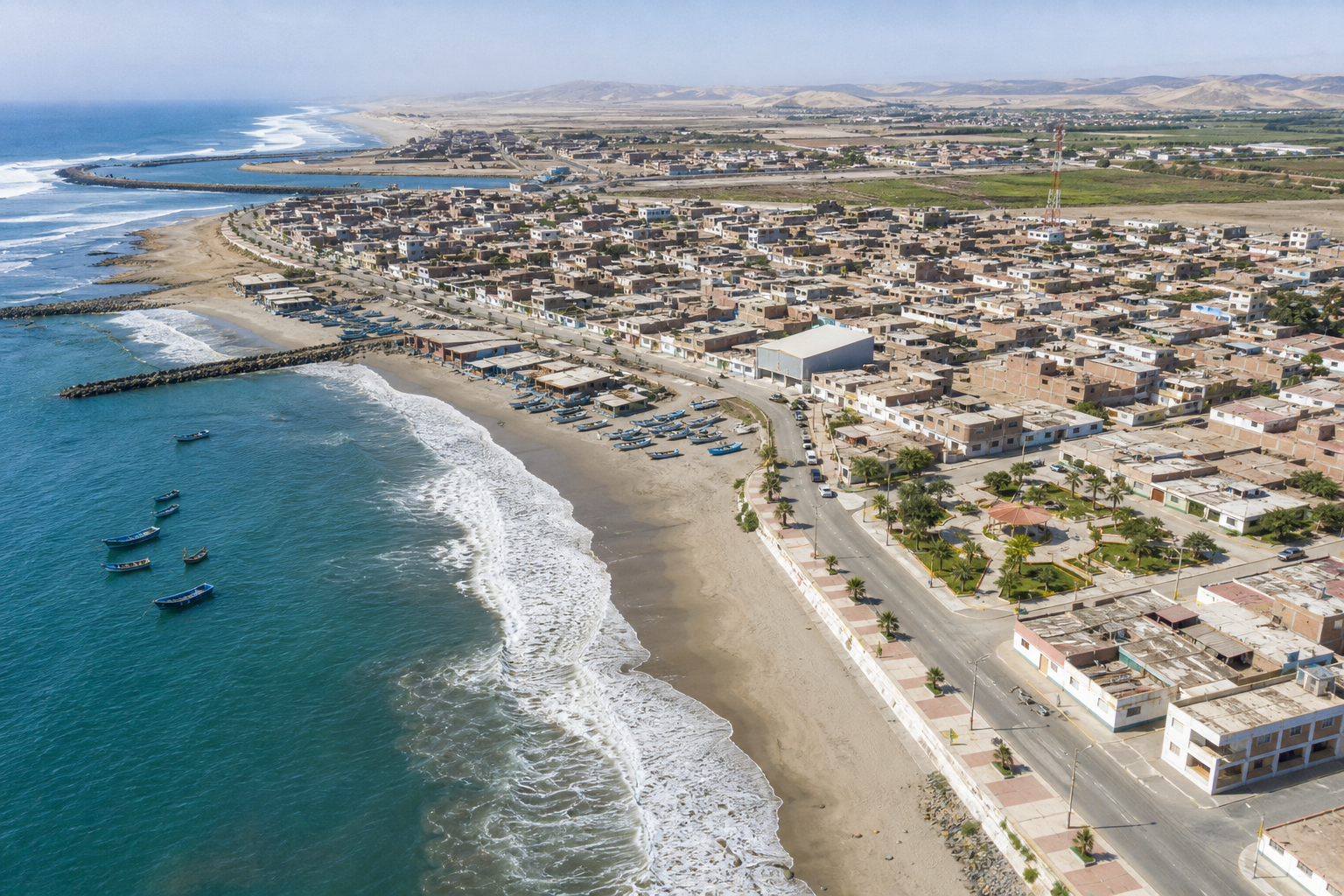 Vista aérea costera del distrito de San José en Lambayeque, con línea de playa, viviendas y actividad local junto al mar