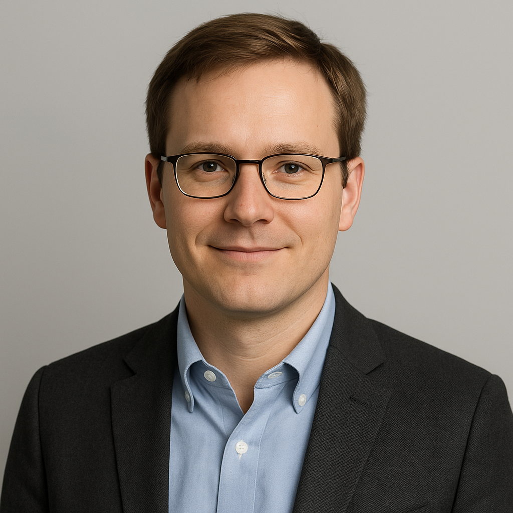 Portrait of Maksym, a man with light brown hair and glasses