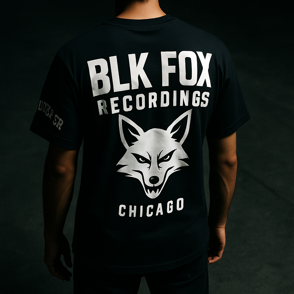 Back view of a black streetwear tee with oversized back print and sleeve detail, photographed on dark concrete