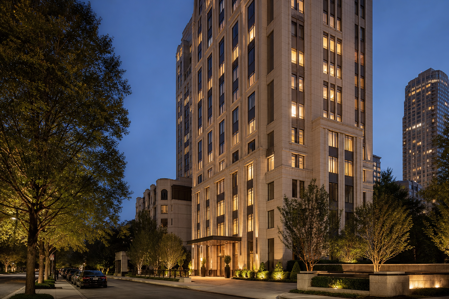 Twilight editorial photograph of an iconic American limestone high-rise residence with warm interior lighting, quiet avenue foreground, and balanced architectural lines