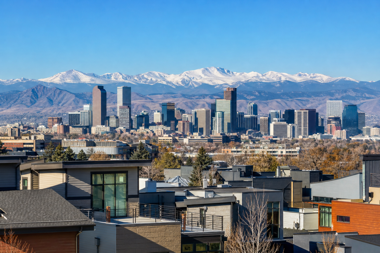 Wide view of the Denver skyline with Front Range mountains in the background under clear Colorado daylight