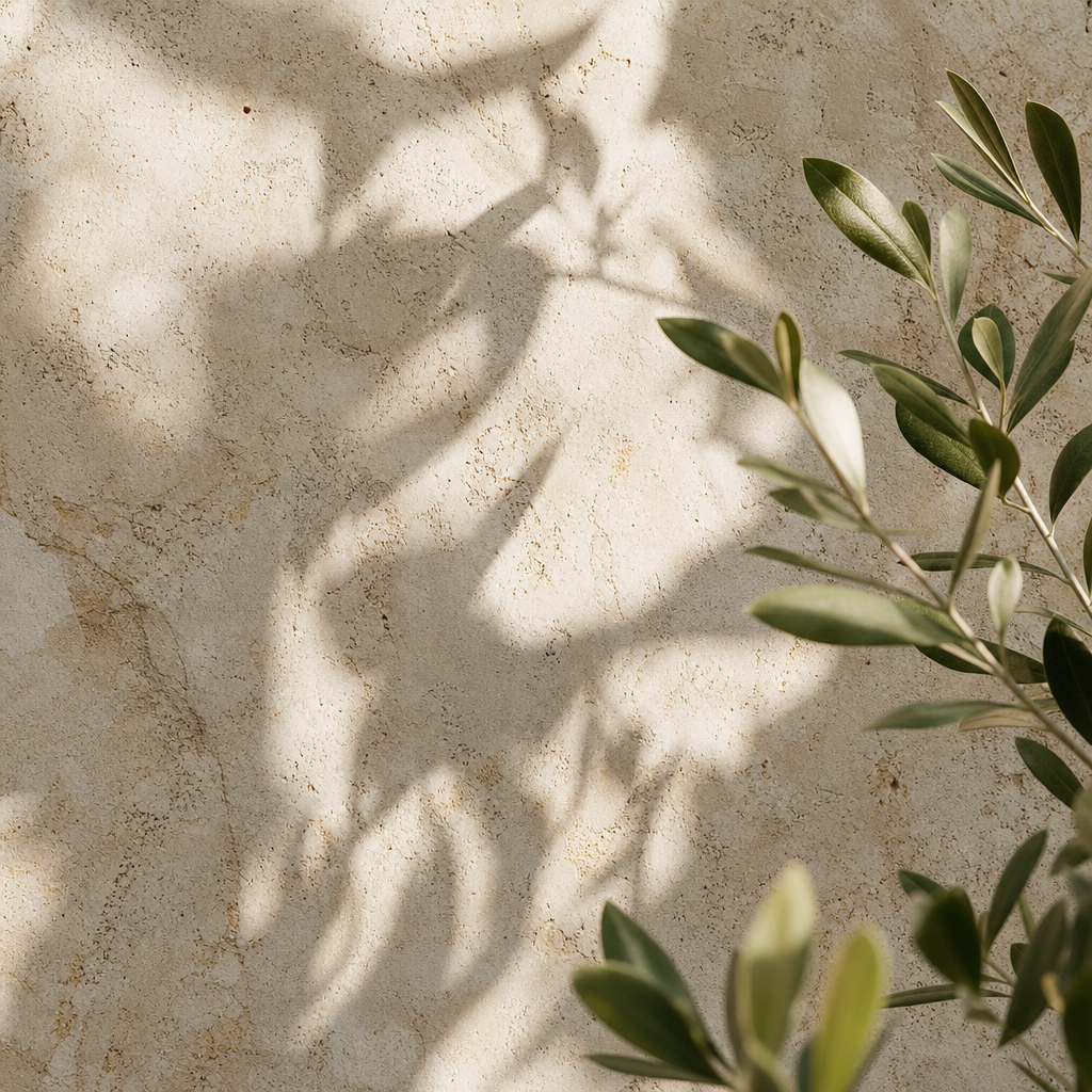 Contained close-up panel of natural limestone texture, green botanical shadows, and soft tactile detail