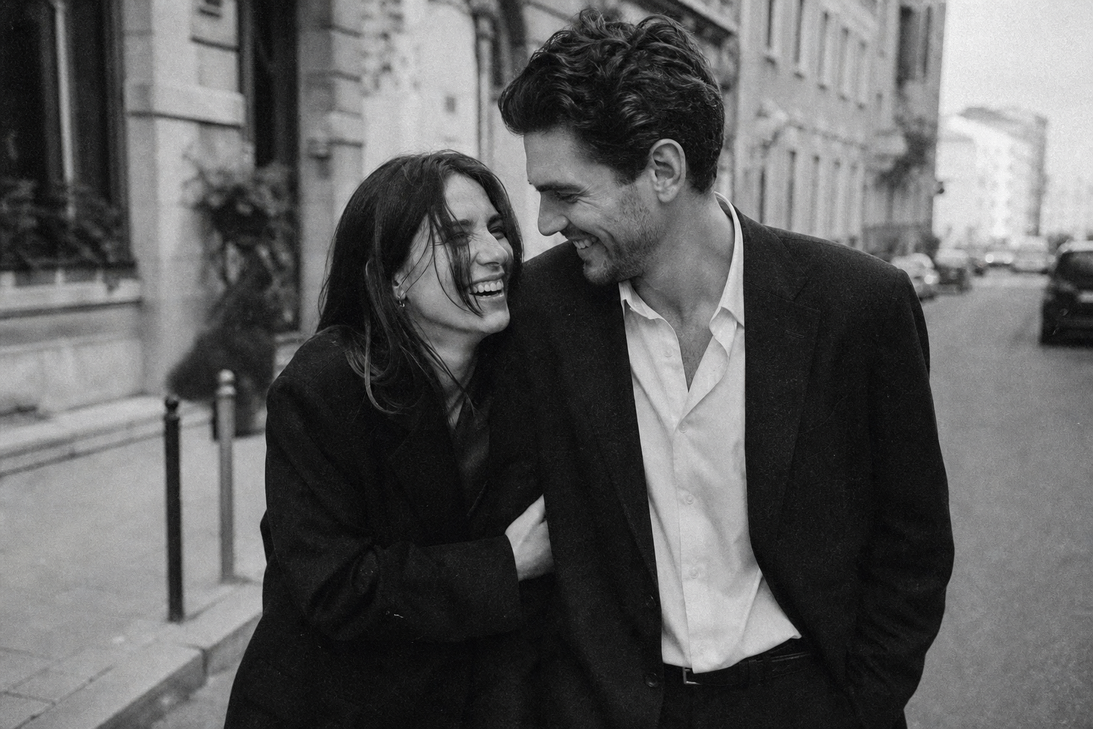Grainy black and white film photograph of a couple laughing together on a city street