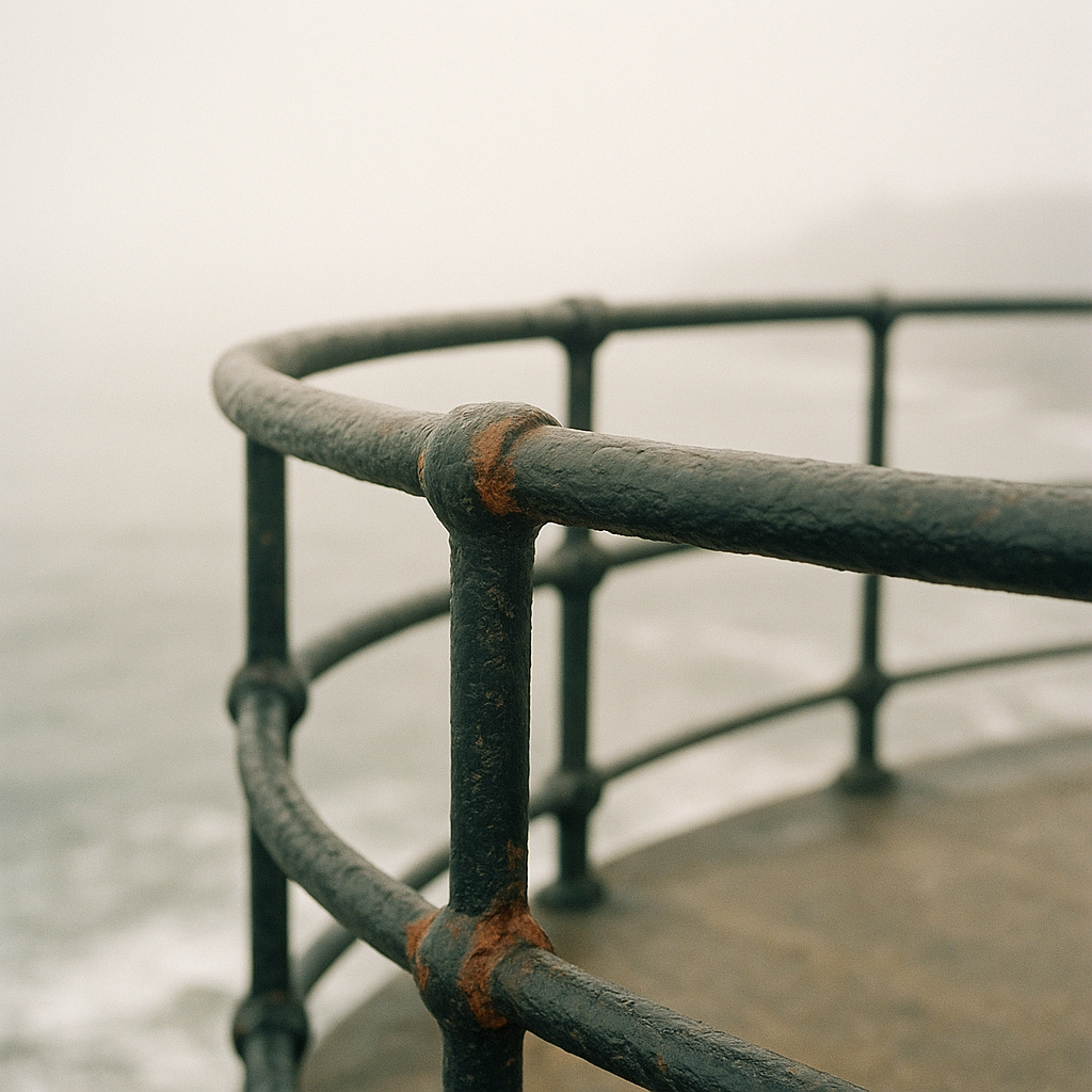 Cast-iron gallery railing with worn black finish and orange rust edges