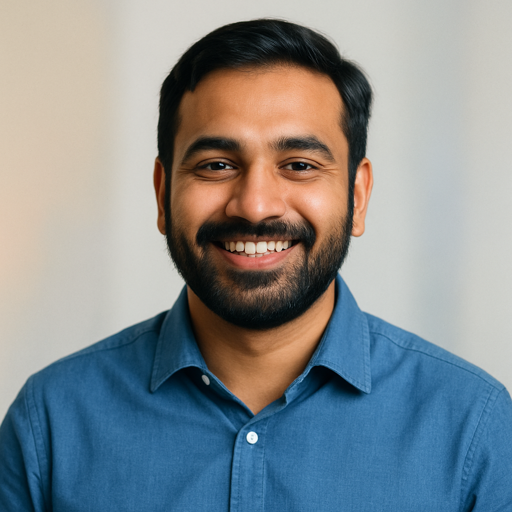 Raj Patel, South Asian man, beard, blue shirt, warm smile