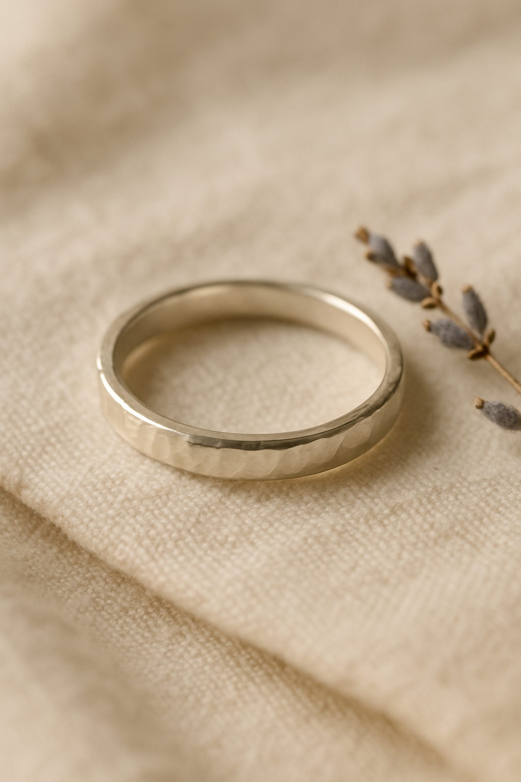 Elegant handmade silver ring with delicate texture on a linen surface