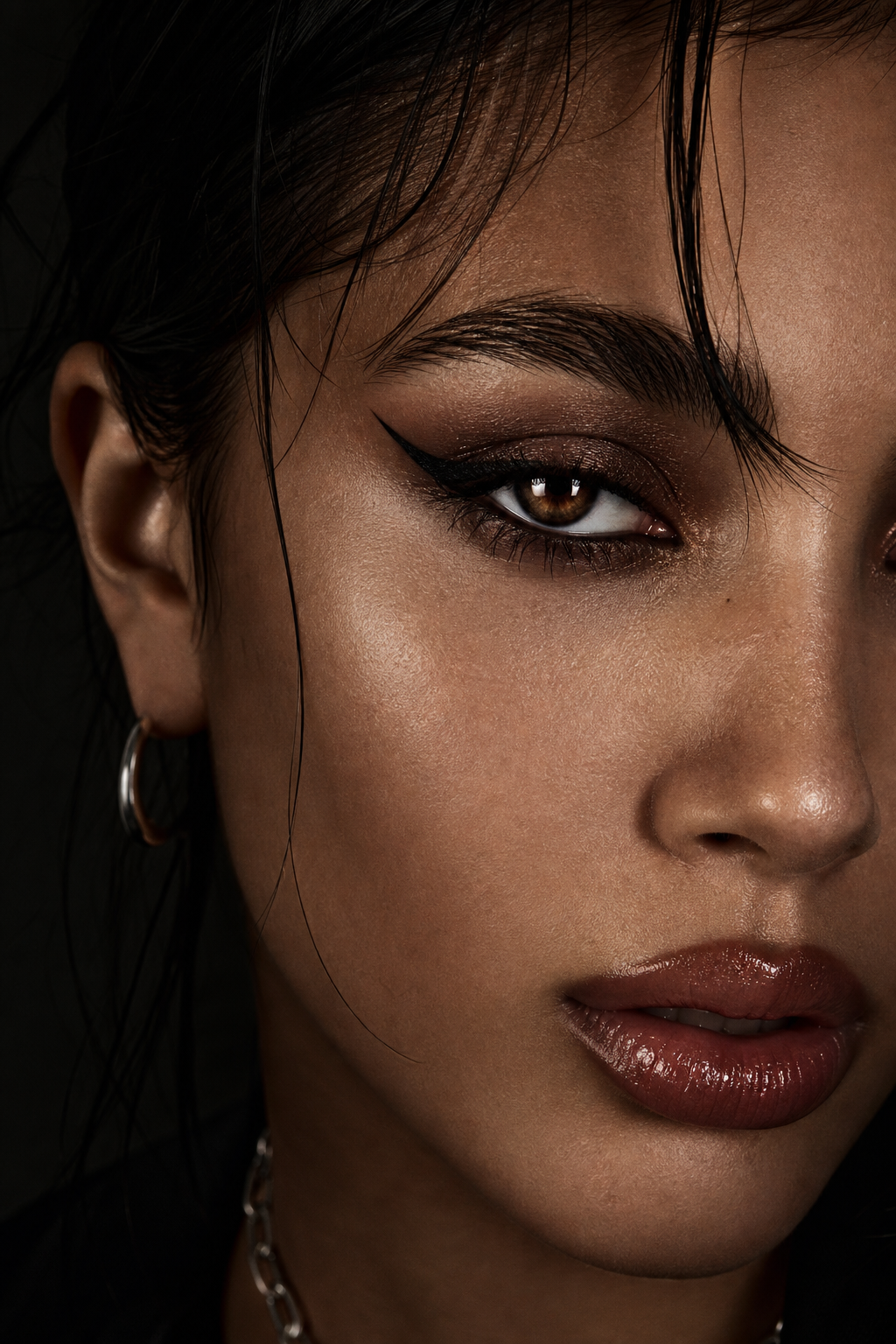 Beauty closeup portrait with glossy makeup detail, sharp eye focus, and soft shadow gradients on dark background