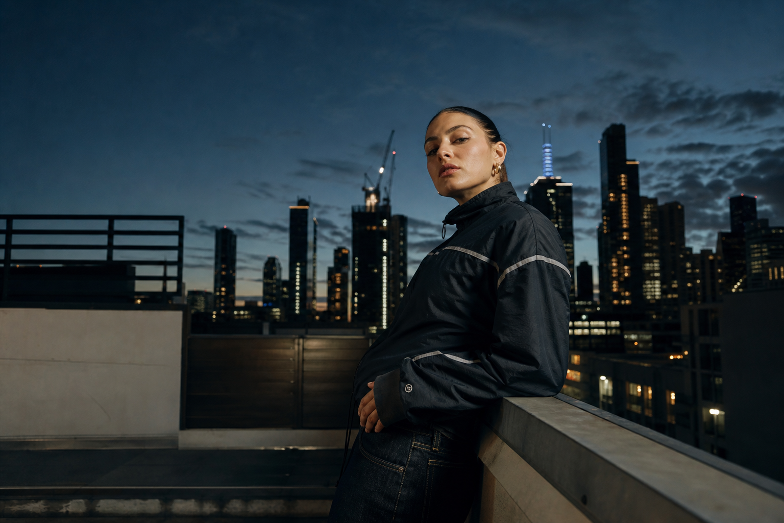 Rooftop campaign frame at dusk with skyline backdrop, directional flash, and cinematic shadows