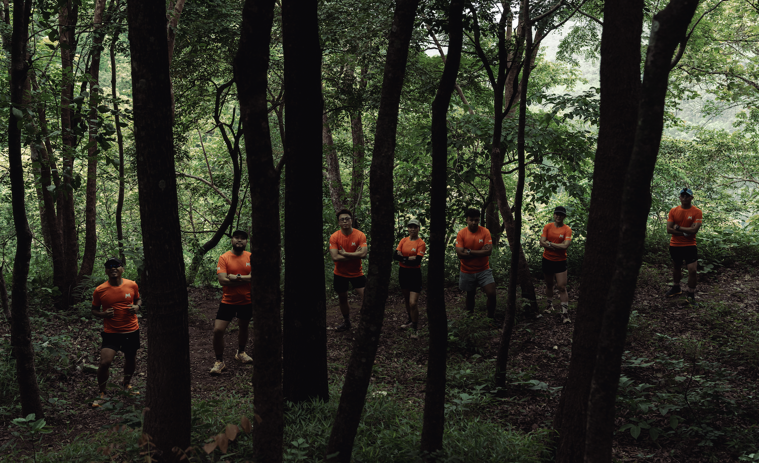 Trail runners moving through a rugged forest path during a UMTR jungle race in Pyin Oo Lwin