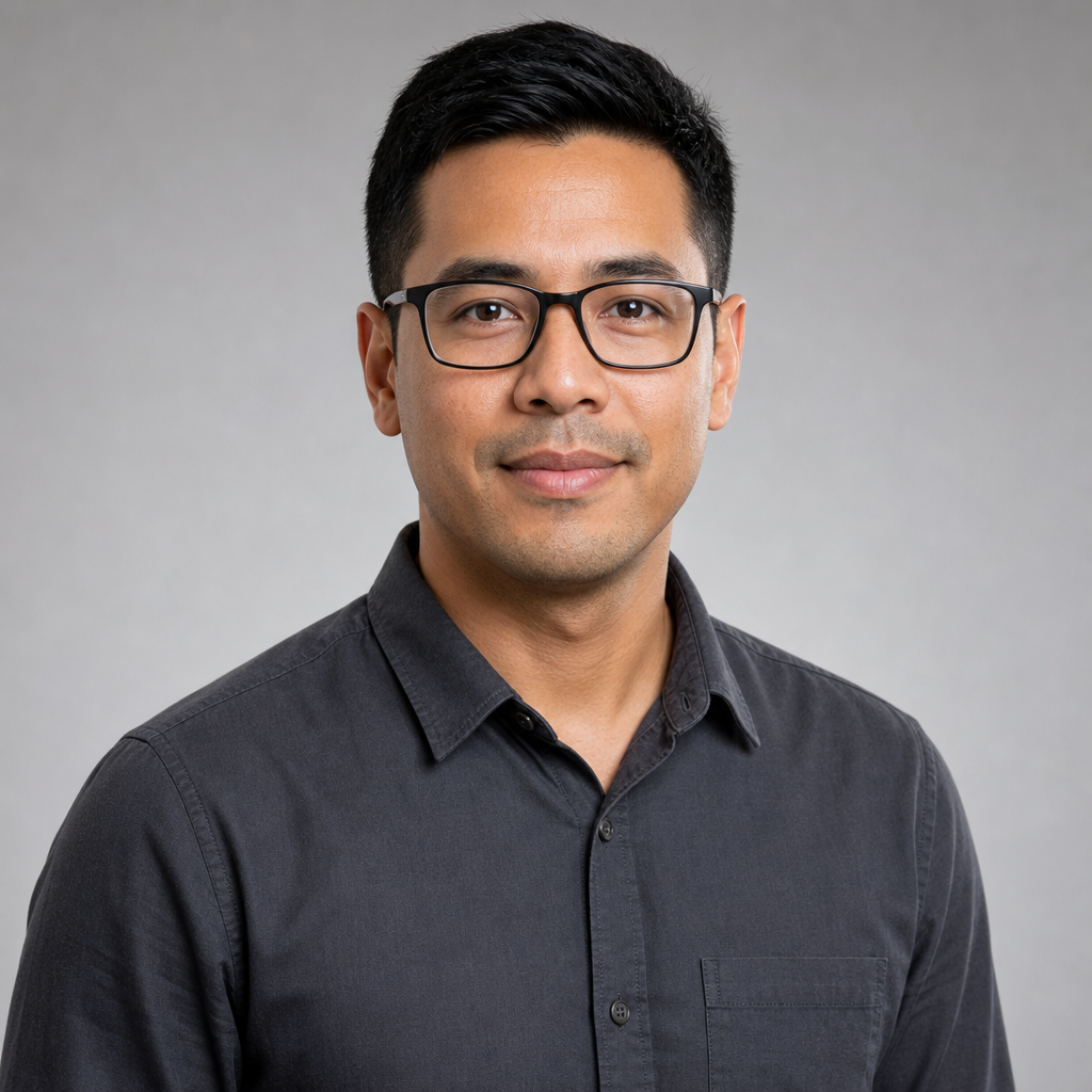 Professional headshot of Marcus Lee, a hosting specialist with short hair, glasses, and a charcoal shirt