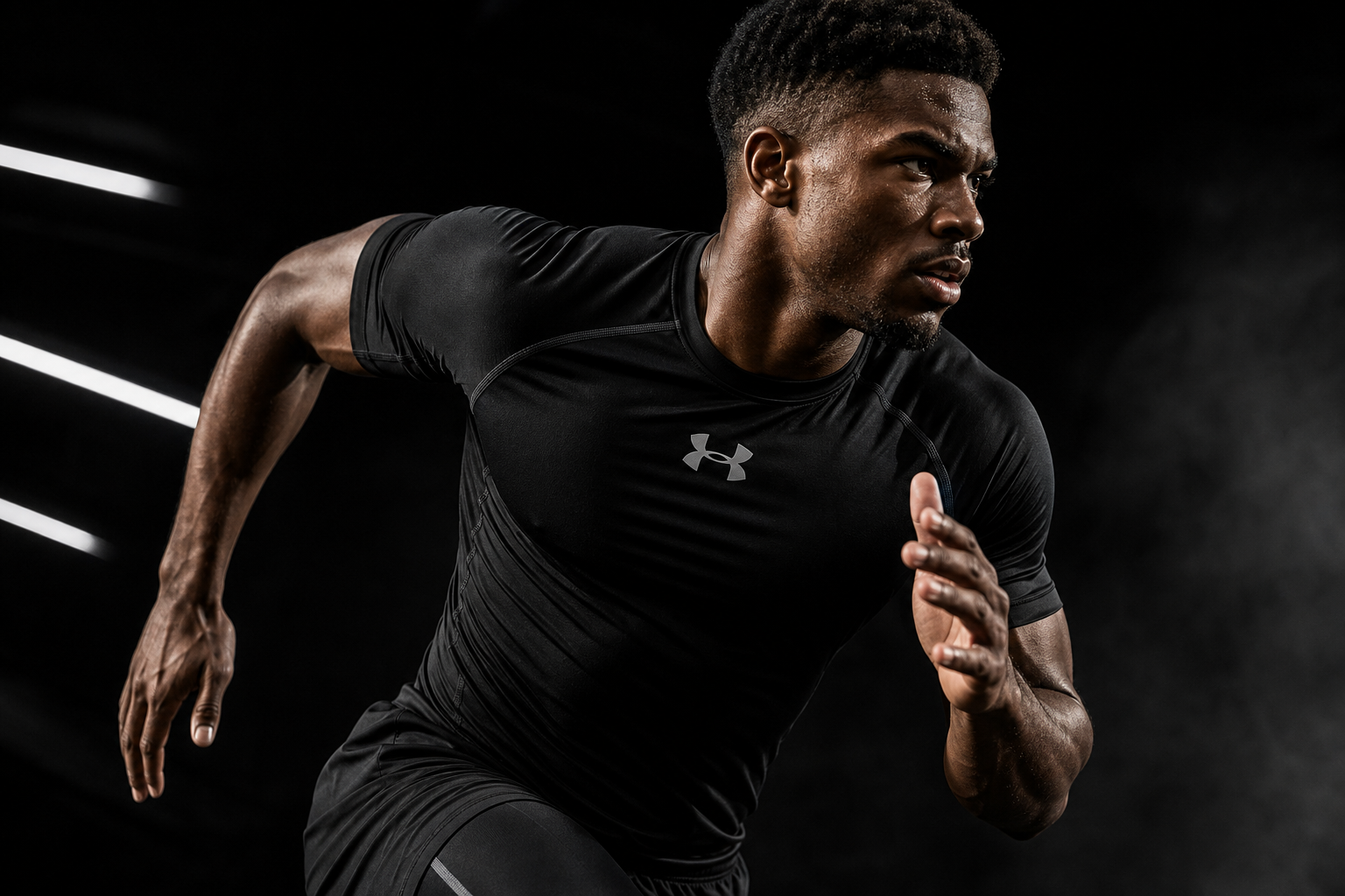 Under Armour athlete in a black compression shirt sprinting under dramatic studio lights