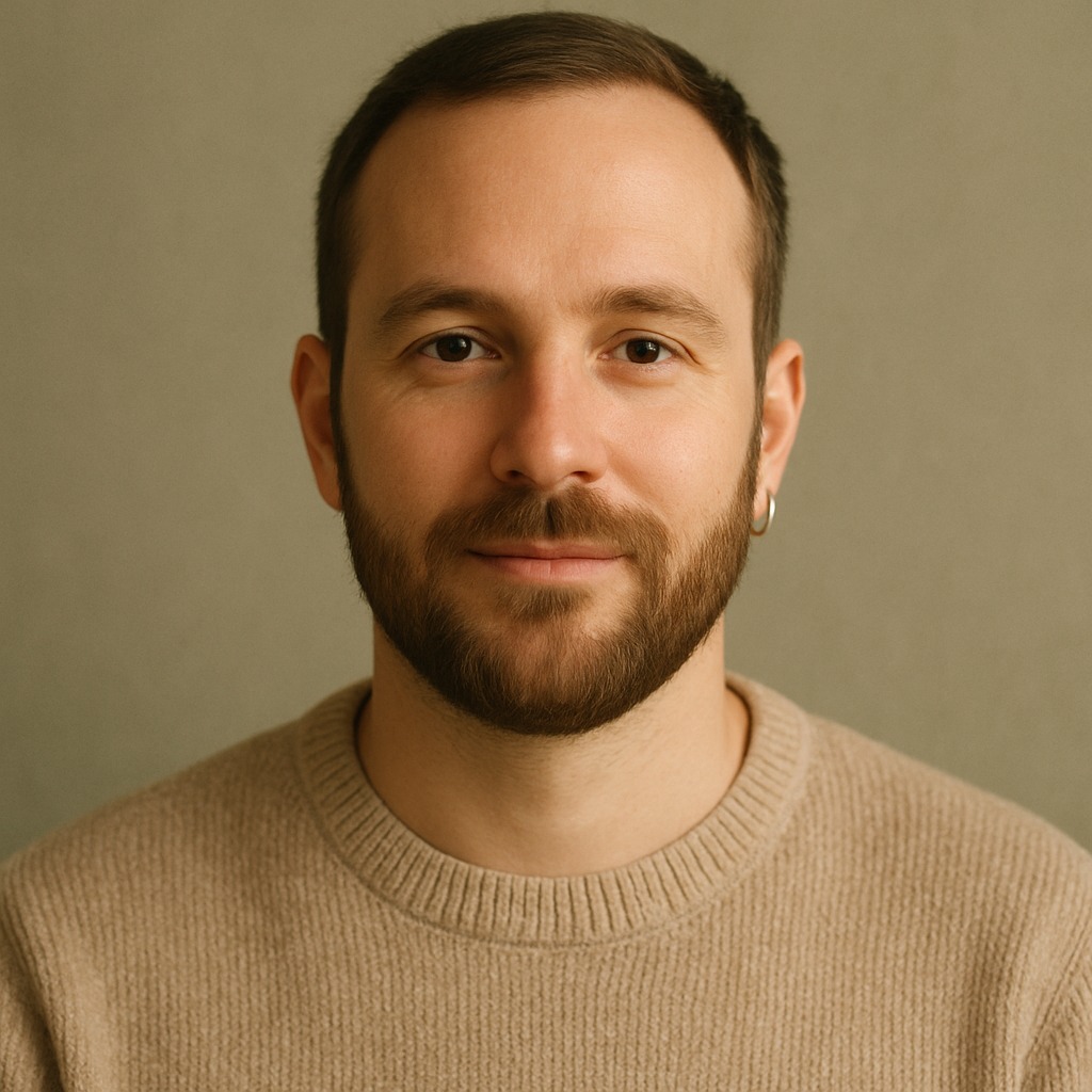 Portrait of Marco L., a man with a short beard wearing a beige sweater