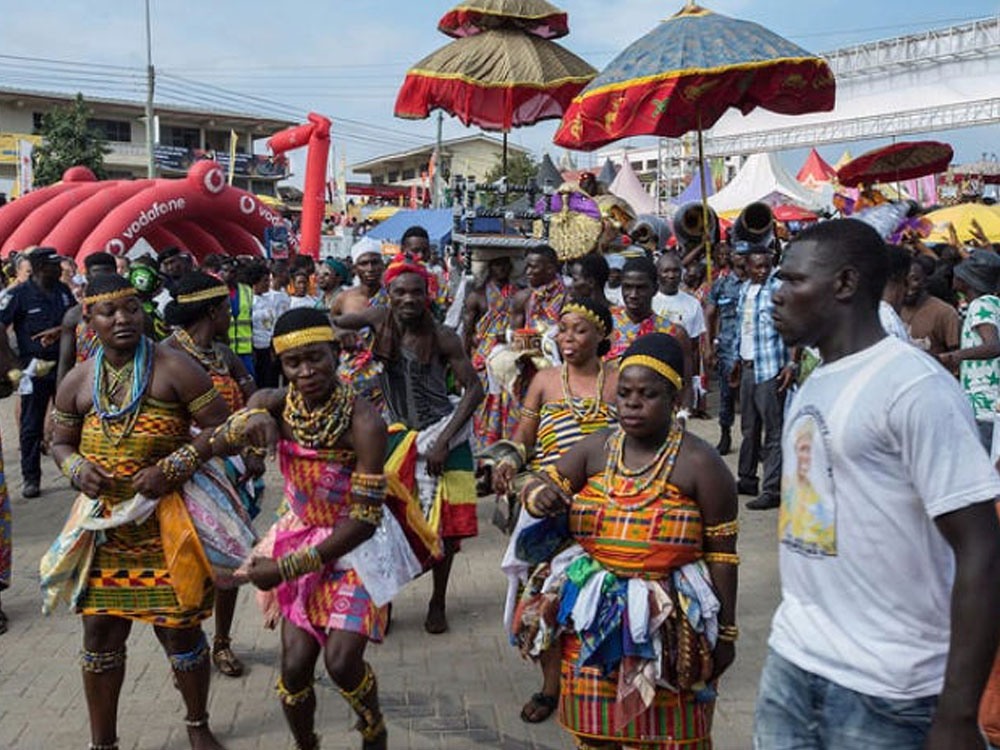 Lively street community event with dancers in colorful traditional dress surrounded by festival crowds